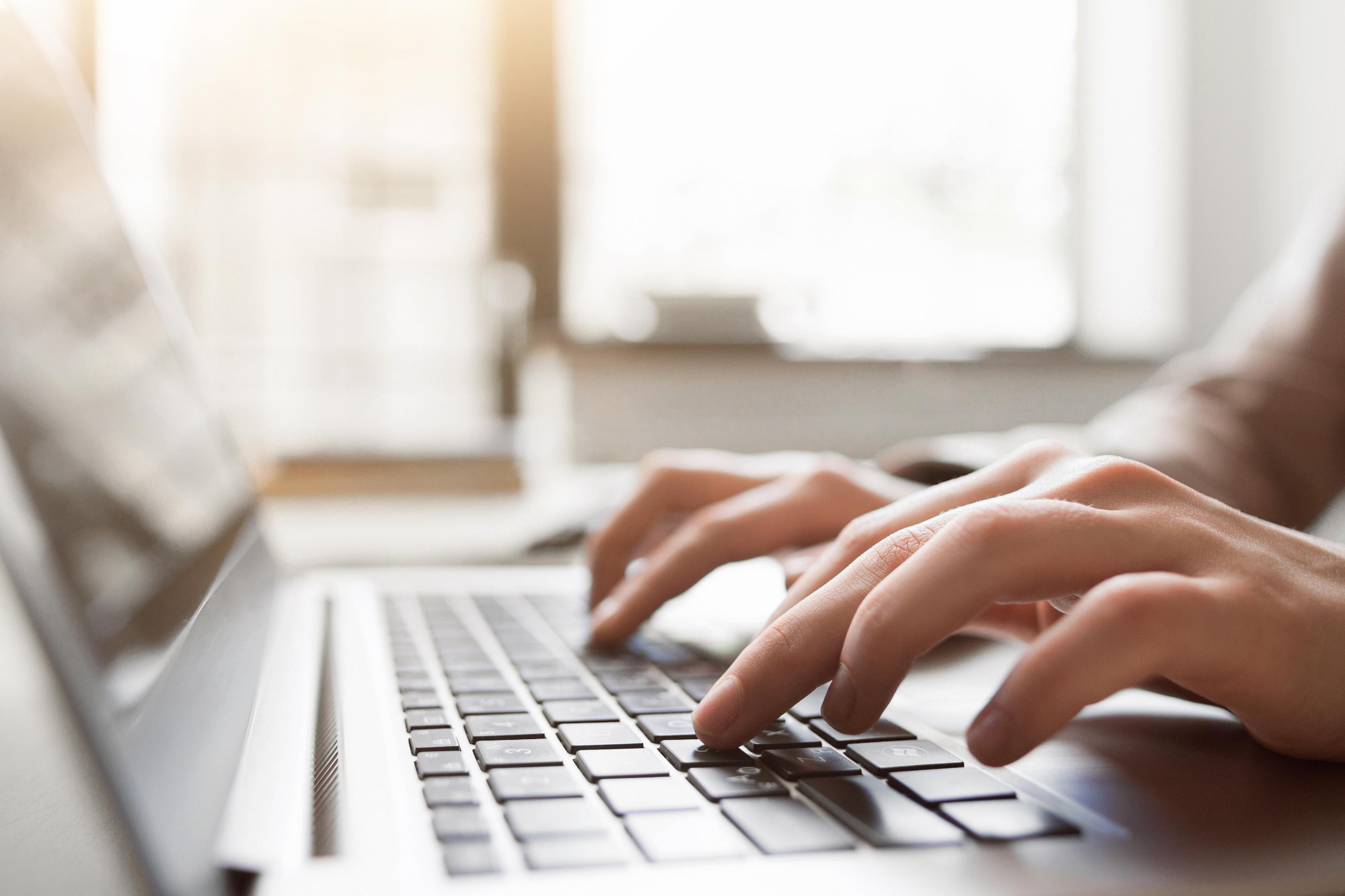 hands typing on a laptop